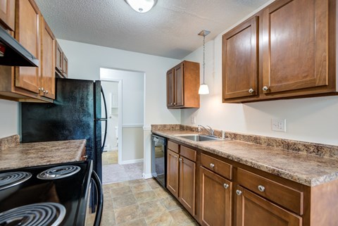 a kitchen with wooden cabinets and a black stove and refrigerator