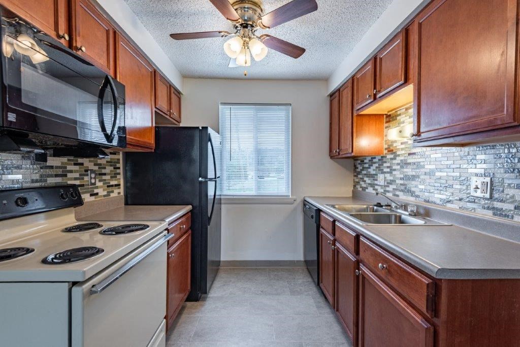 a kitchen with a stove refrigerator and sink