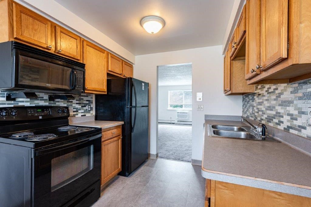 a kitchen with black appliances and wooden cabinets