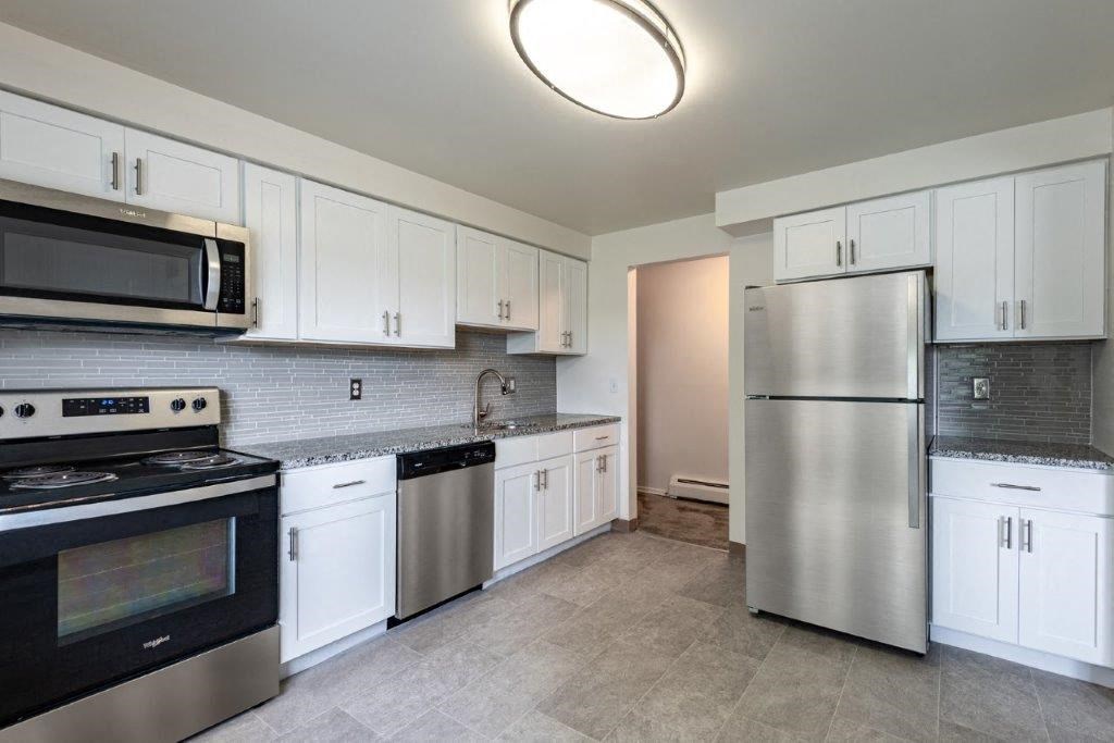 a kitchen with stainless steel appliances and white cabinets