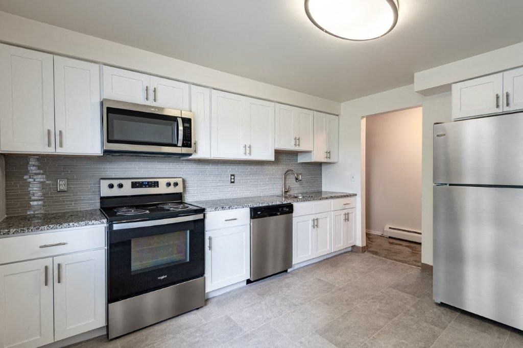 a kitchen with stainless steel appliances and white cabinets