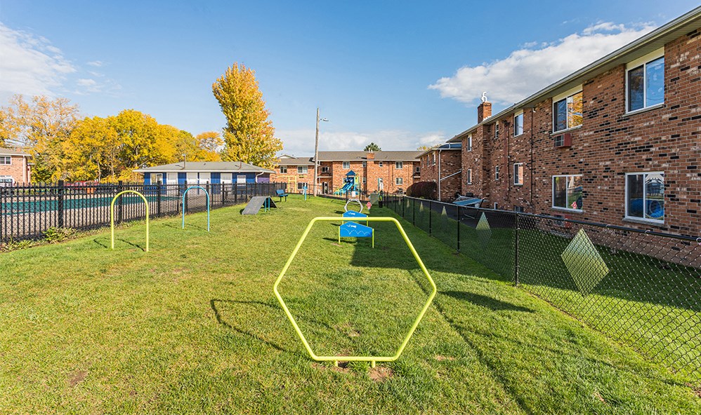 the yard is fenced in with yellow cones on the grass