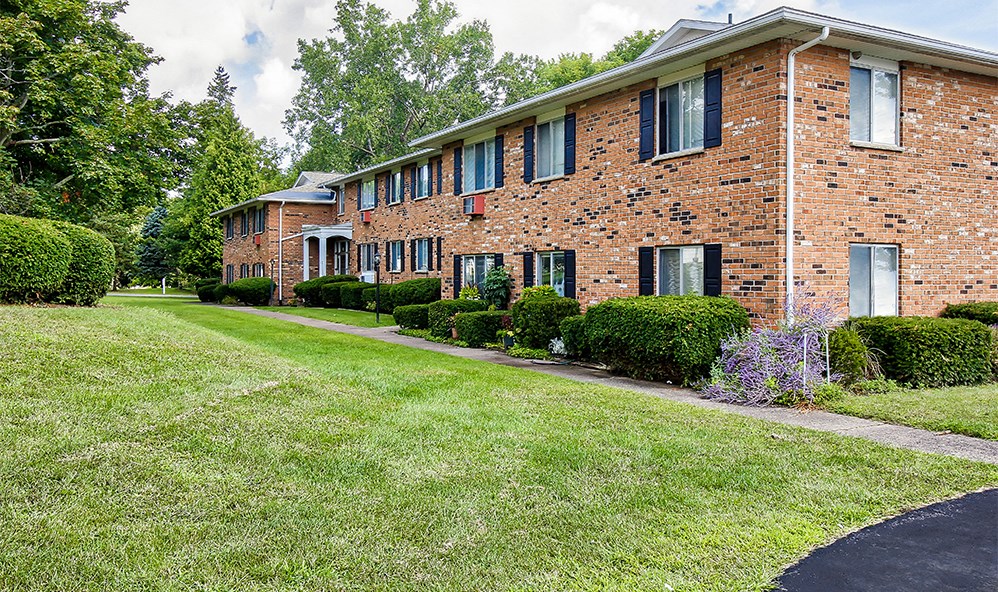a large brick house with a lawn in front of it
