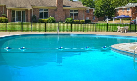 a large swimming pool with a house in the background