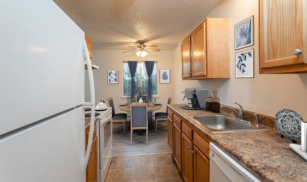 a kitchen with a sink and a refrigerator and a dining room