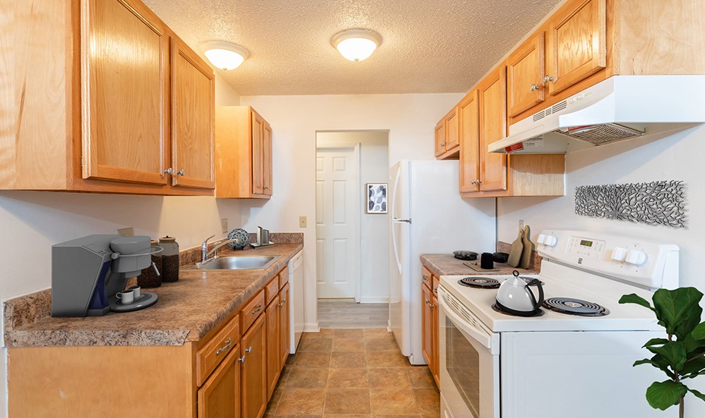 a kitchen with wood cabinets and white appliances and a stove top oven