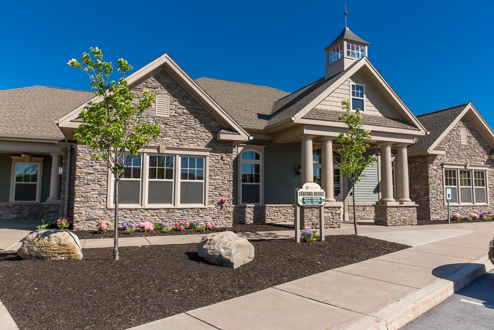 the front of a house with a sidewalk and a street sign