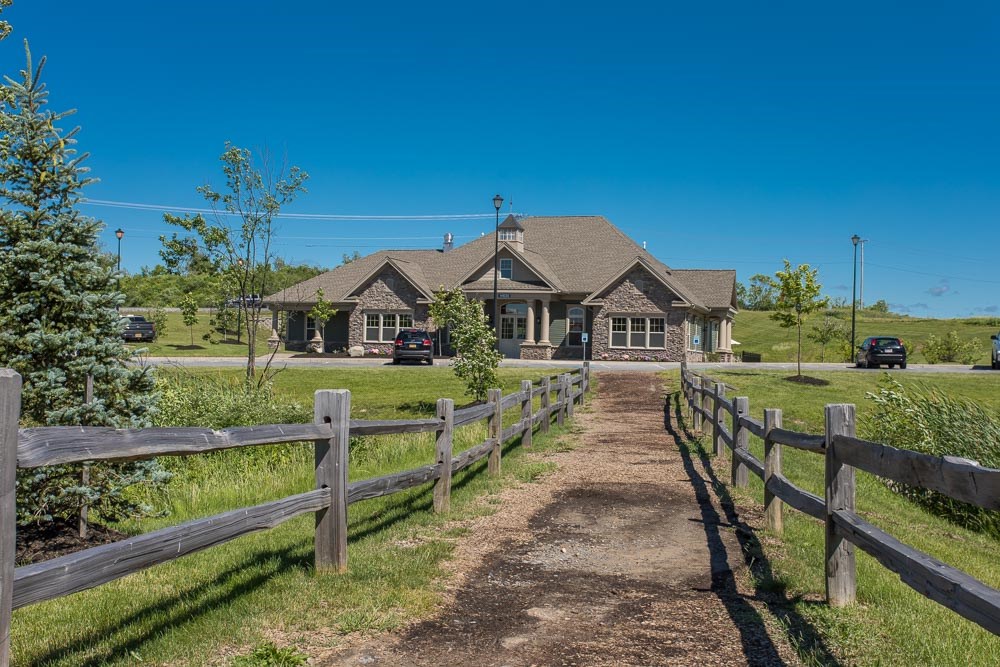 a house with a dirt path and a wooden fence