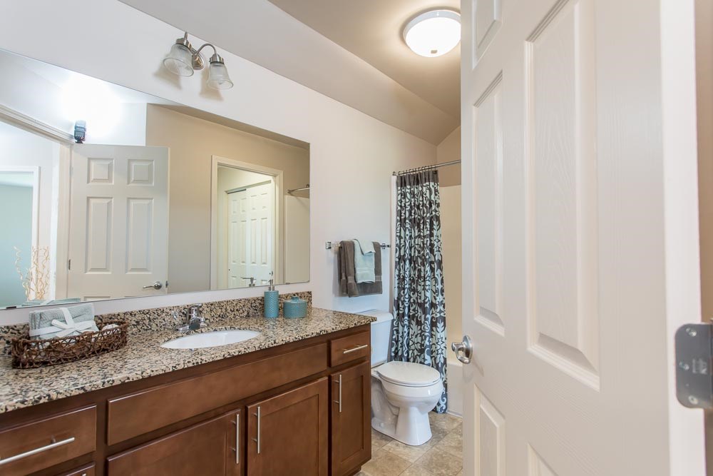 a bathroom with a toilet and a sink and a mirror