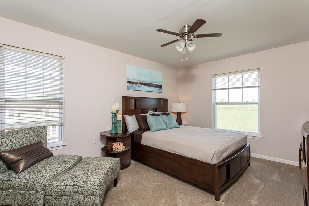 a bedroom with a bed and a ceiling fan