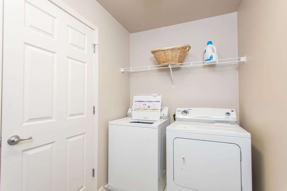 a white washer and dryer in a laundry room with a white door