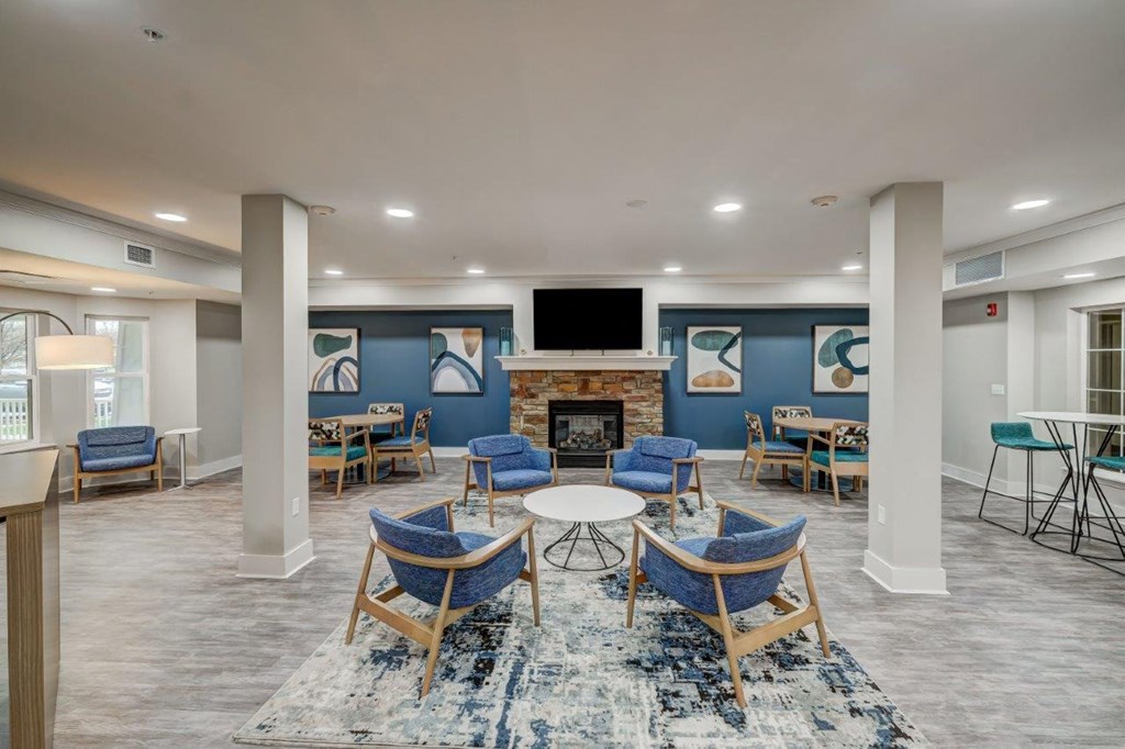 a clubhouse with tables and chairs and a fireplace