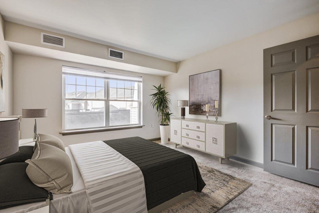 a bedroom with a bed and a dresser and a window