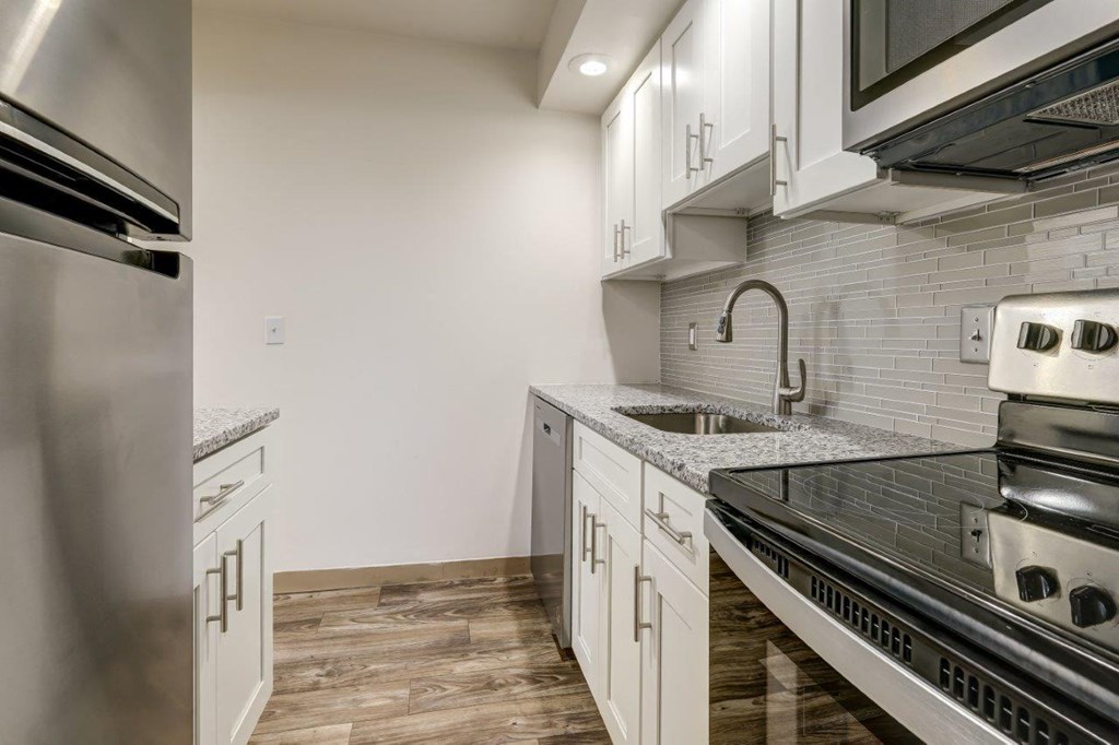 a kitchen with white cabinets and stainless steel appliances
