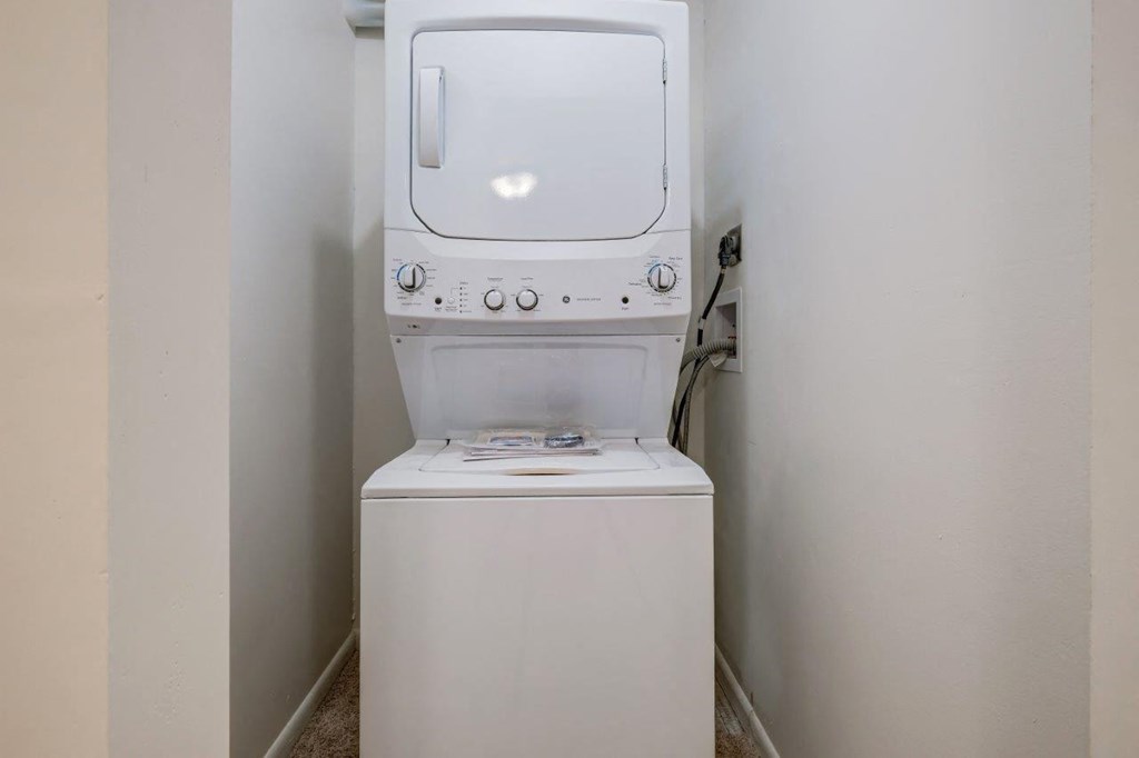 a washer and dryer in a closet in a white room