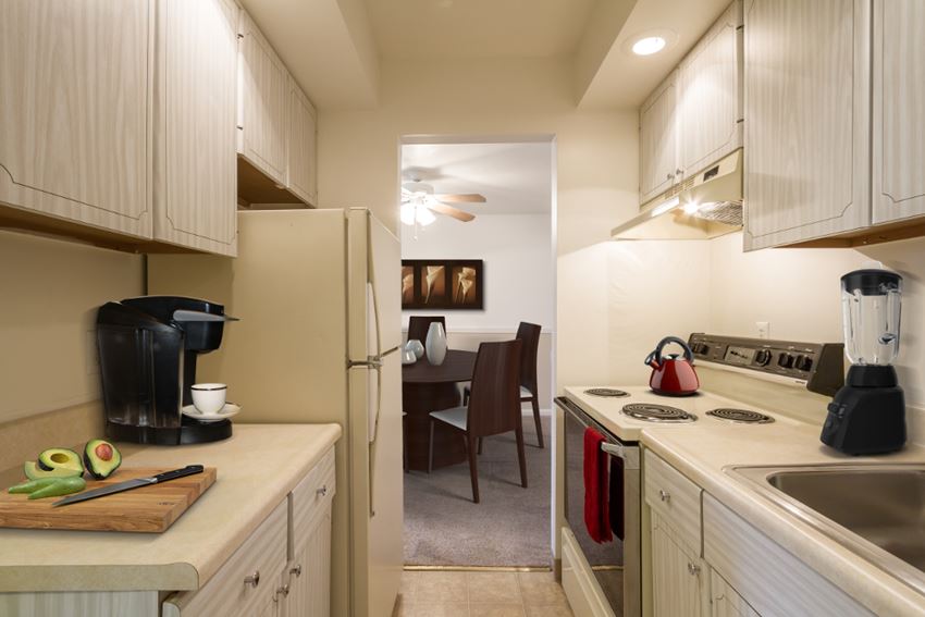 a kitchen with a stove and a refrigerator and a dining room