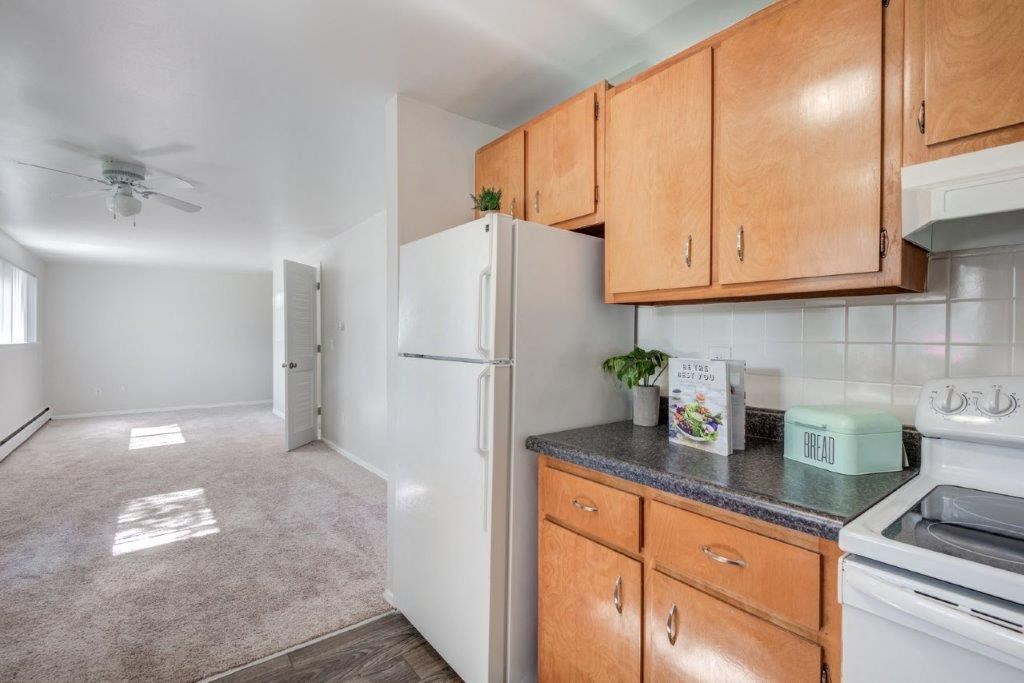 a kitchen with white appliances and wooden cabinets