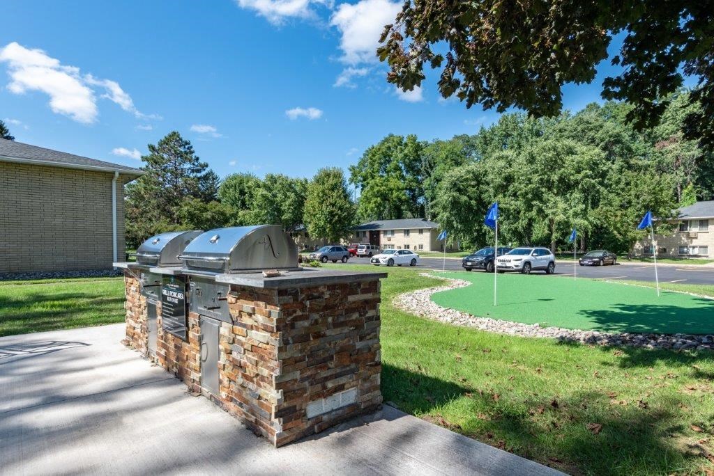 a brick column with a grill on the side of a driveway