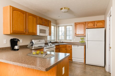 A kitchen with wooden cabinets and a white refrigerator.