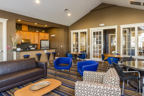 A living room with a brown couch and blue chairs.