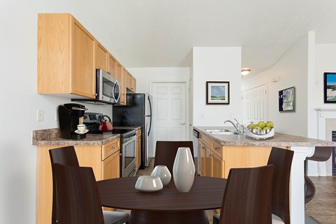 A kitchen with a table and chairs in the foreground.