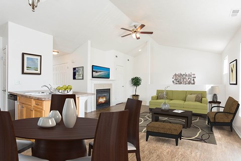 A modern living room with a fireplace and a dining table set for two.