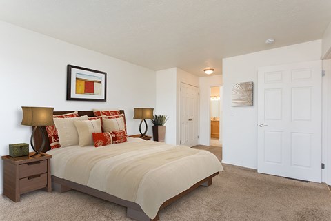 A bedroom with a large bed and a painting on the wall.