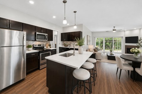 A modern kitchen with dark wood cabinets and stainless steel appliances.