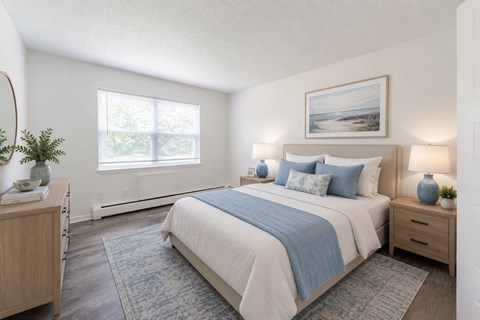 A bedroom with a large bed and a window.