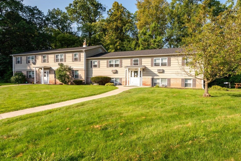 a couple of houses on the side of a sidewalk