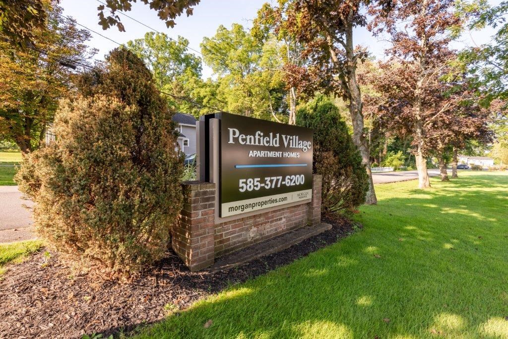 a sign for the peninsula villas apartments on the side of the street