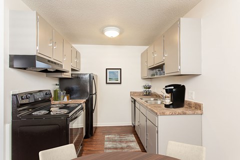 a kitchen with a stove refrigerator and sink