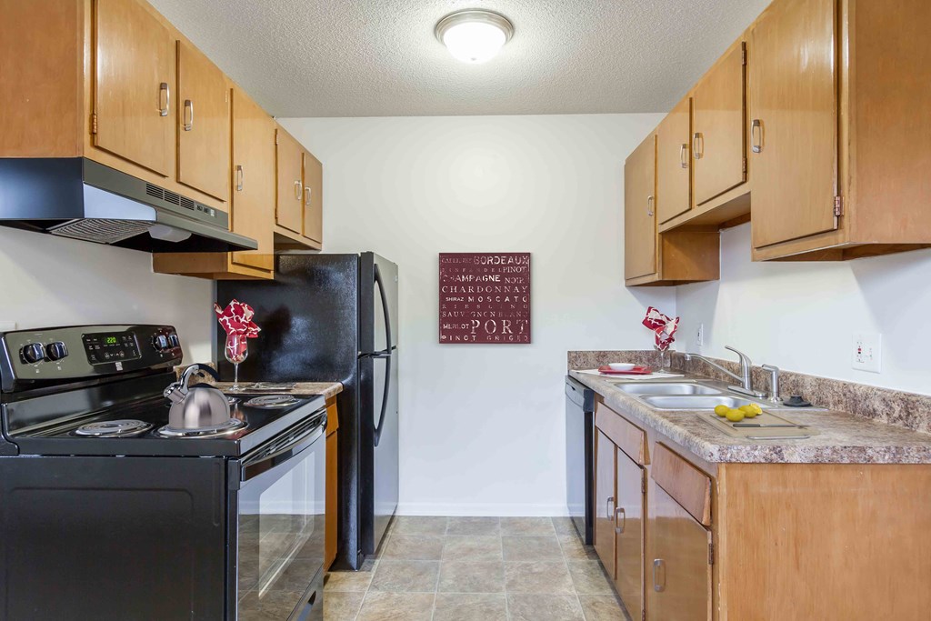 a kitchen with a stove refrigerator and sink