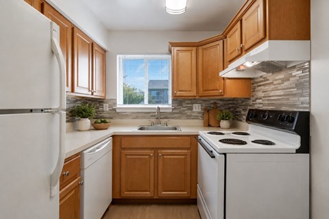 A kitchen with wooden cabinets and white appliances.