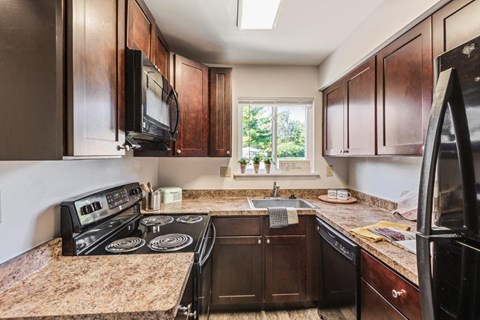 a kitchen with black appliances and brown cabinets