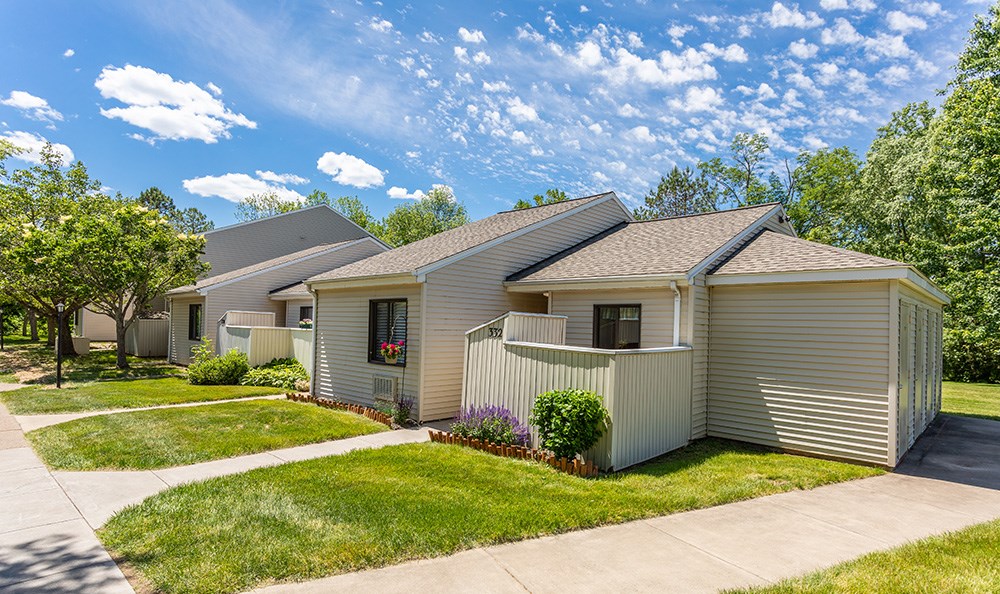 a gray house with a sidewalk in front of it