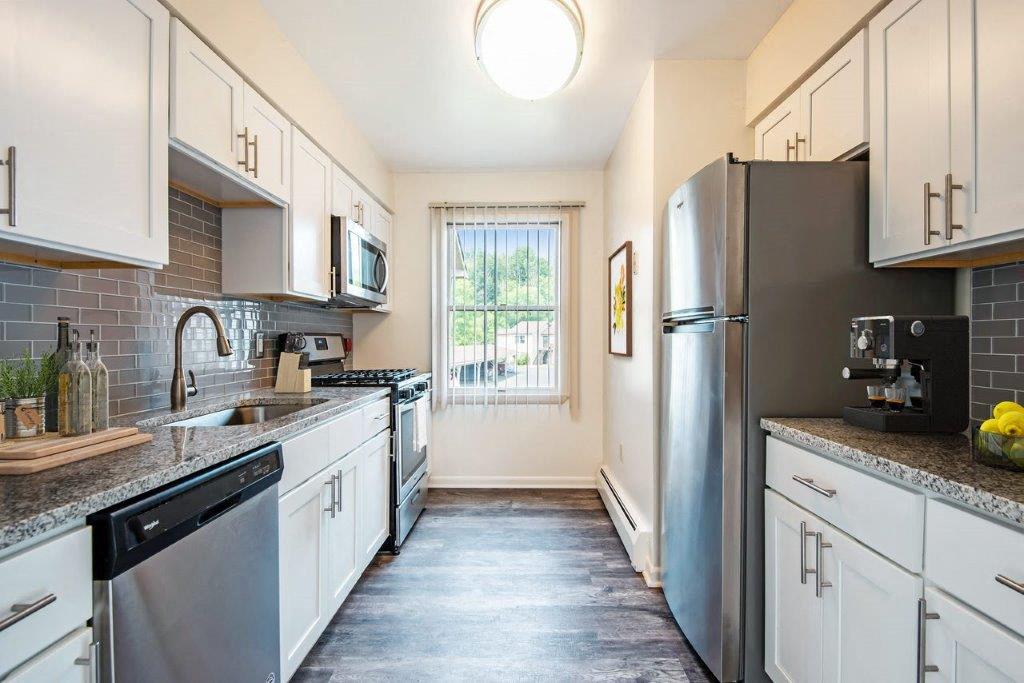 kitchen with white cabinets, granite counters, and stainless appliances