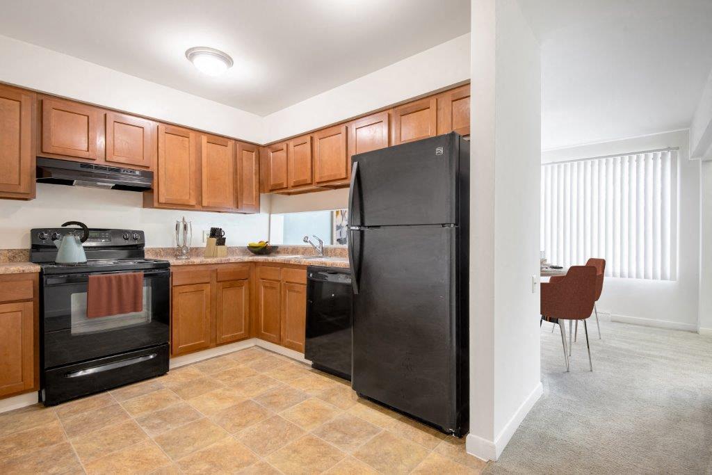 Kitchen with maple cabinets and black appliances