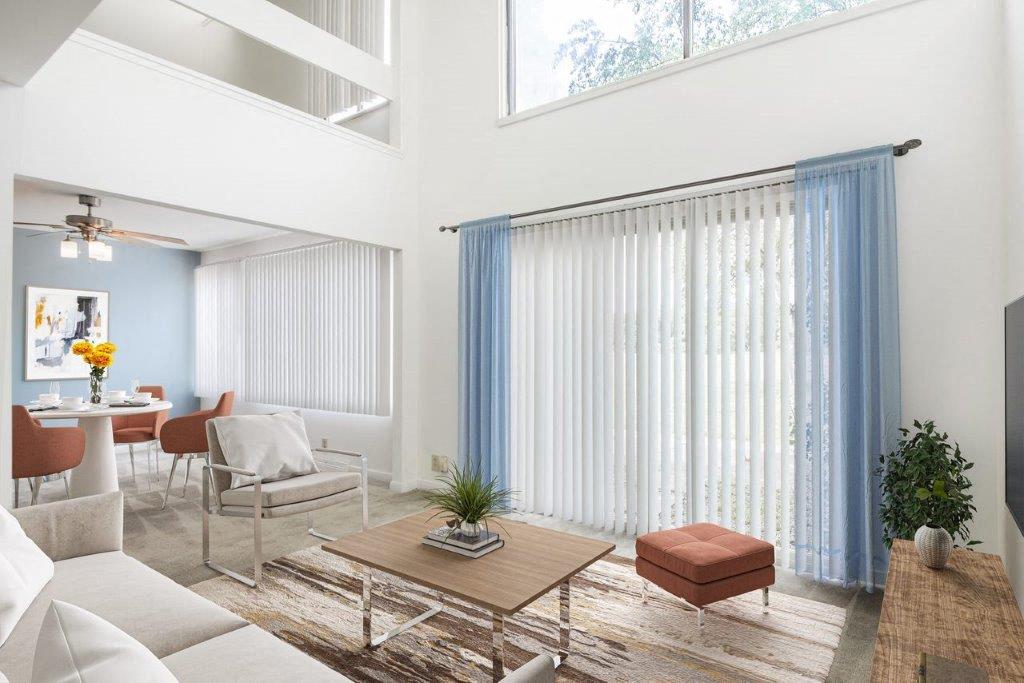 staged living room with extra high ceilings and sliding door to patio