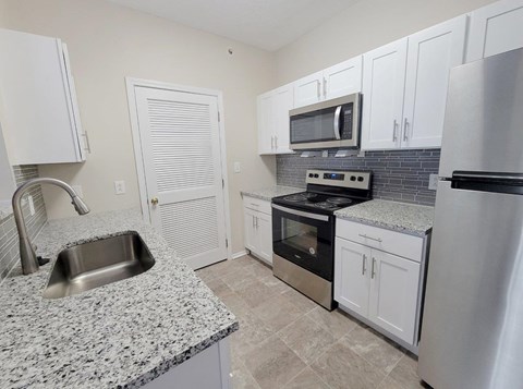 a kitchen with granite counter tops and stainless steel appliances