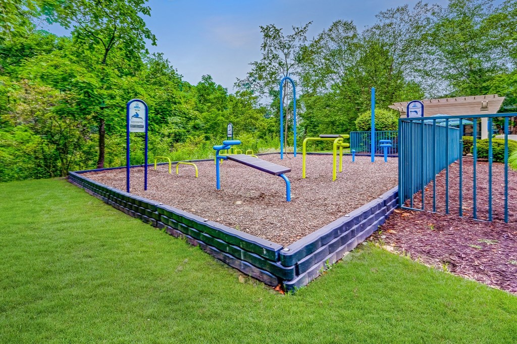 a playground with a blue gate and a bench