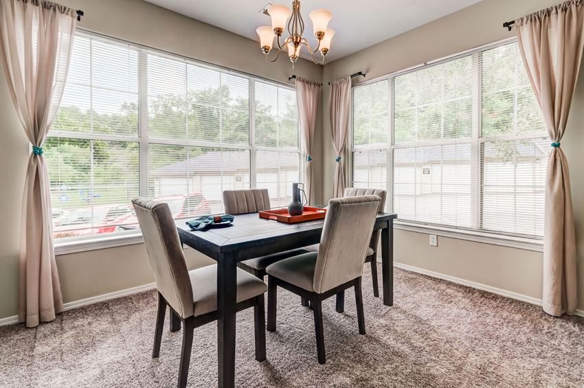 a dining room with large windows and a table and chairs