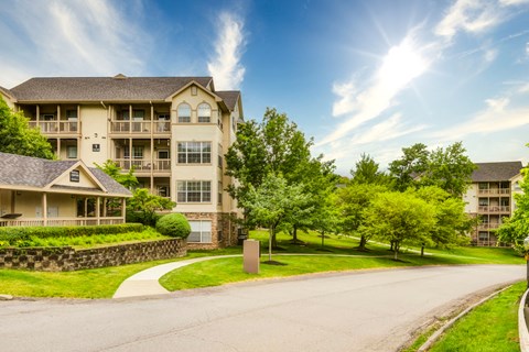 an apartment building on the side of a road with the sunburst in the sky