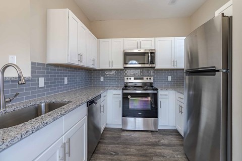 A kitchen with a stove top oven and a refrigerator.