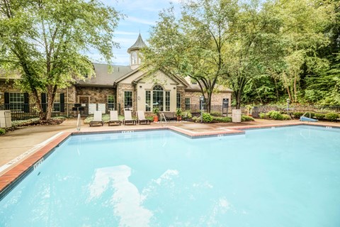 a swimming pool with a house in the background