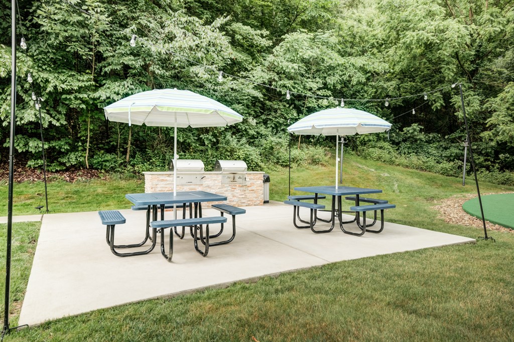 two picnic tables with umbrellas on a patio