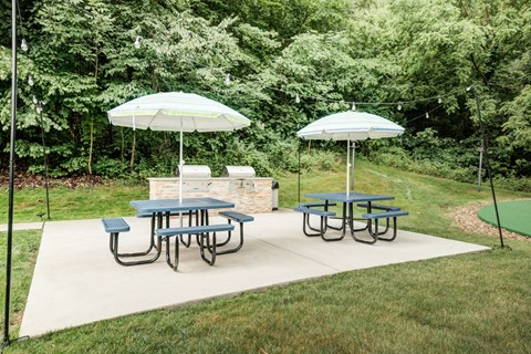 two picnic tables with umbrellas on a patio