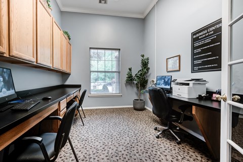 an office with a desk with a computer and a printer