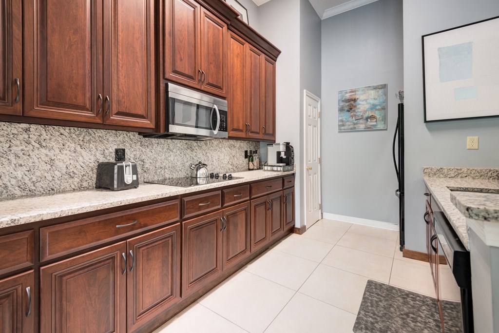 a kitchen with wooden cabinets and a sink and a microwave