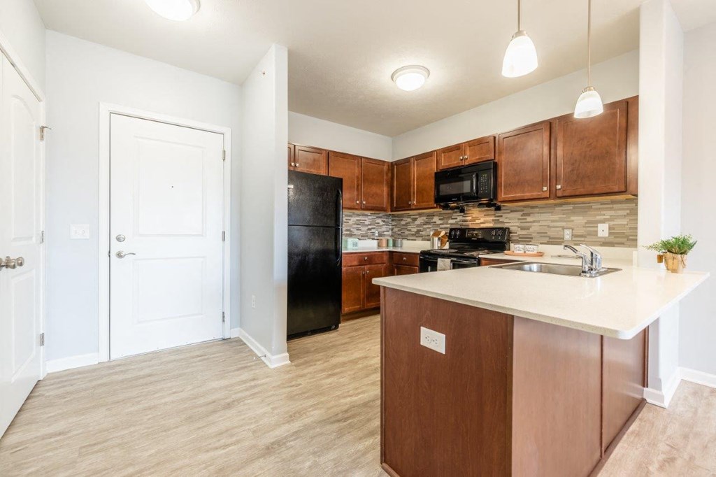 a kitchen with a sink and a black refrigerator
